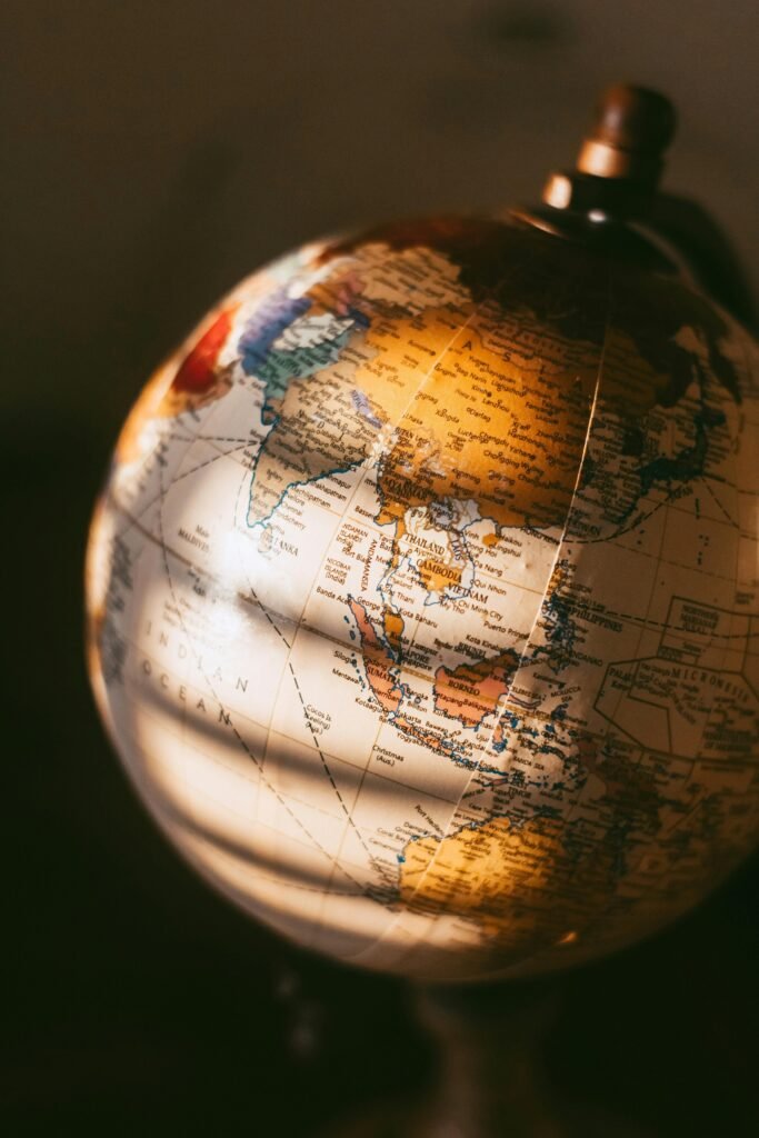 A detailed close-up of a vintage world globe illuminated by warm, soft light.